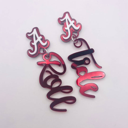 A pair of Alabama Crimson Tide themed drop earrings featuring a white 'A' logo with a red outline on silver-toned hooks, connected to dangling red-to-purple gradient script charms.