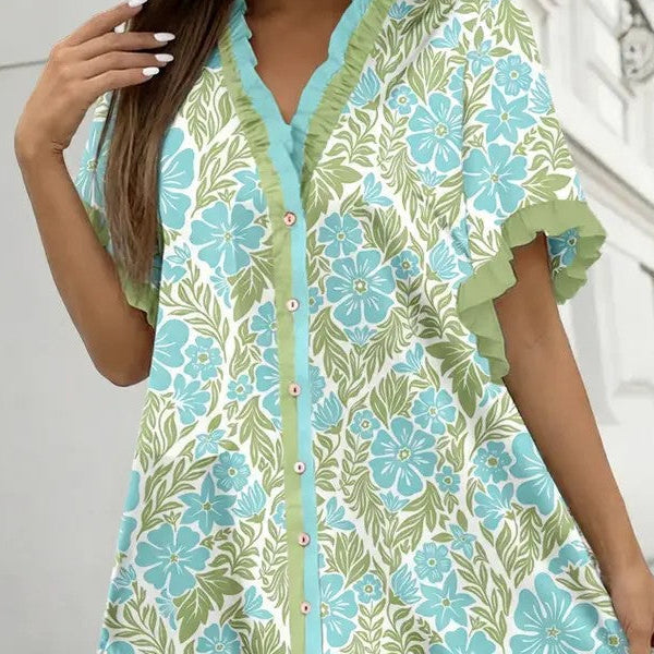 Woman wearing a floral dress with blue and green flowers against a white background
