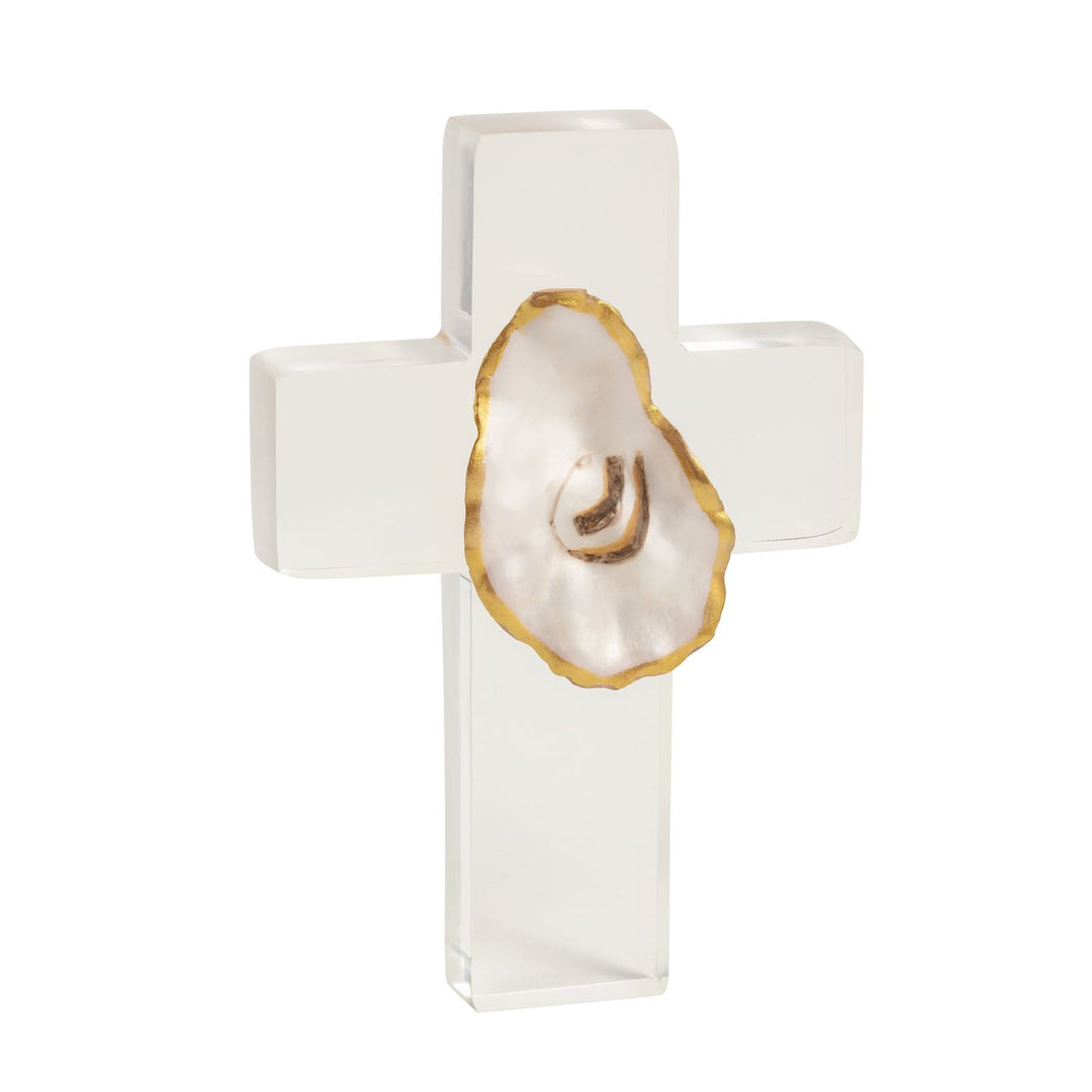 A freestanding clear acrylic cross with a natural oyster shell centered at the intersection, its irregular edge painted gold, displayed against a white background.