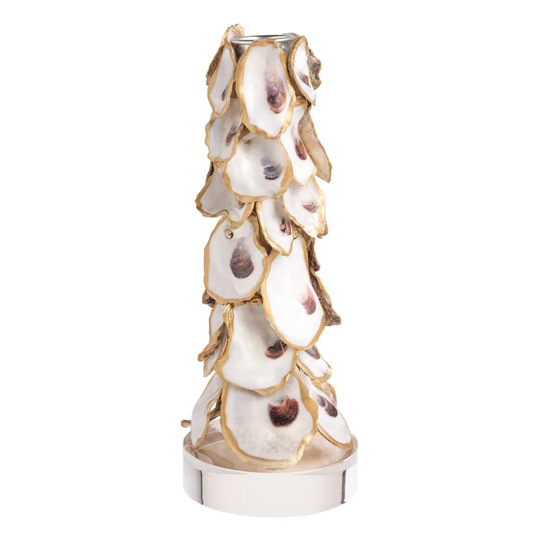 A tall tapered candle holder covered in overlapping oyster shells with gold-edged trim, mounted on a polished silver-tone cylindrical base with a metal candle socket at the top.