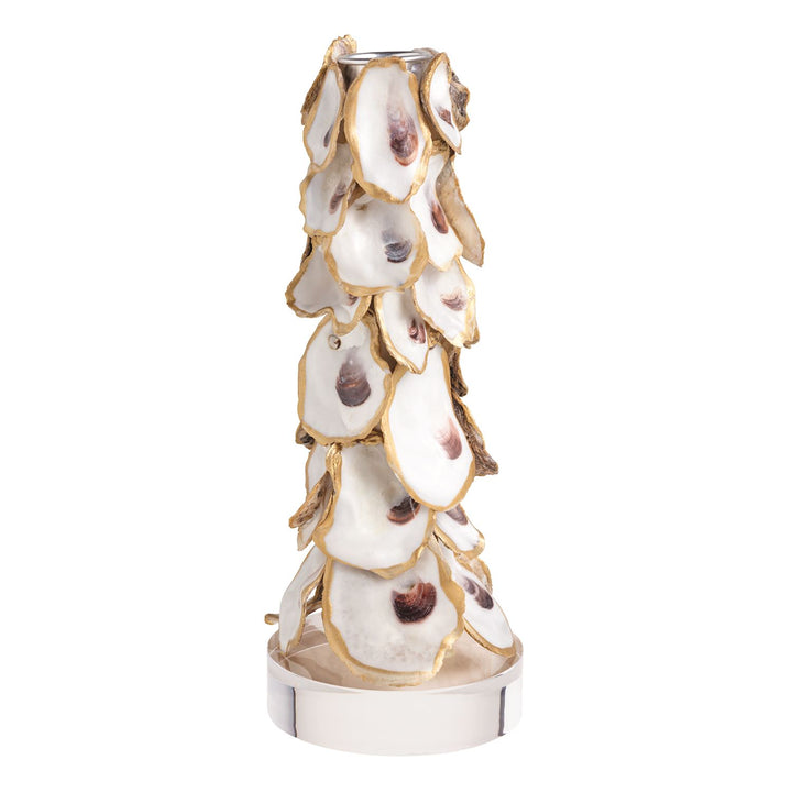 A tall tapered candle holder covered in overlapping oyster shells with gold-edged trim, mounted on a polished silver-tone cylindrical base with a metal candle socket at the top.
