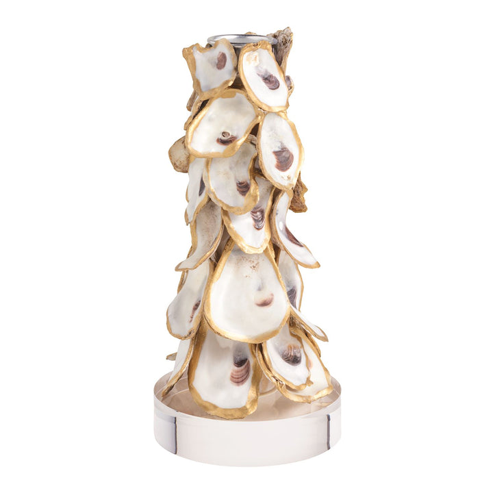 A tall tapered candle holder covered in overlapping oyster shells with gold-edged trim, mounted on a polished silver-tone cylindrical base with a metal candle socket at the top.