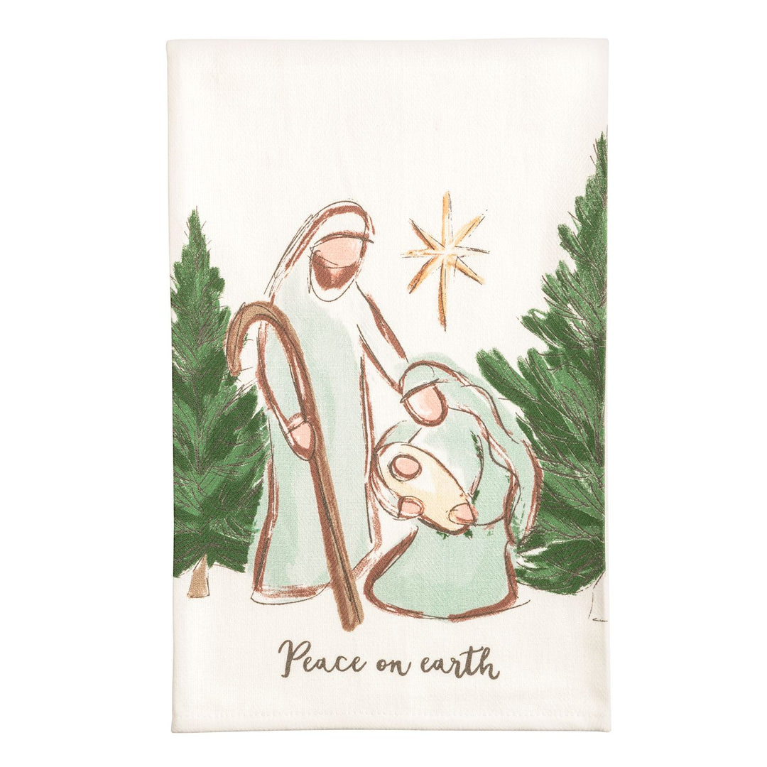 Two cream kitchen towels side by side: the left shows a watercolor nativity stable with a manger, two sheep wearing wreaths, evergreen garland, and the words &