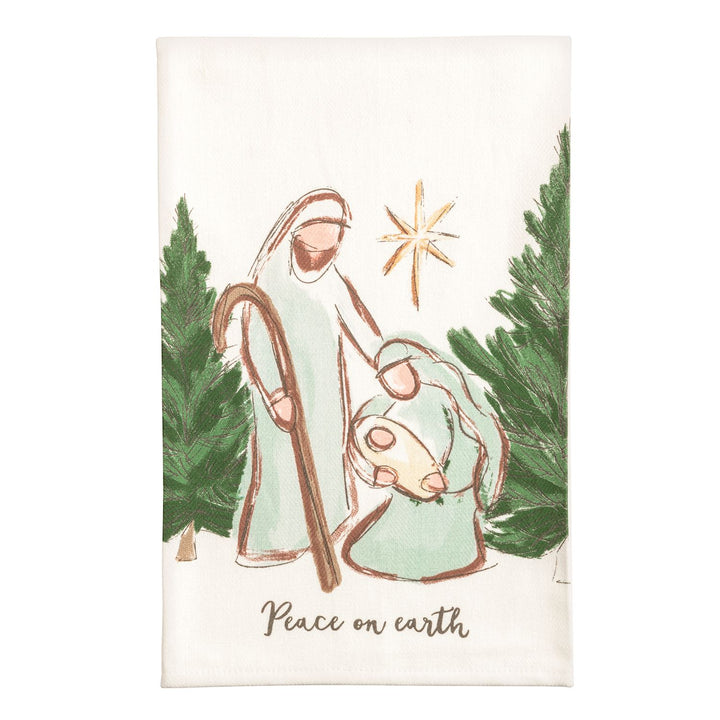 Two cream kitchen towels side by side: the left shows a watercolor nativity stable with a manger, two sheep wearing wreaths, evergreen garland, and the words &