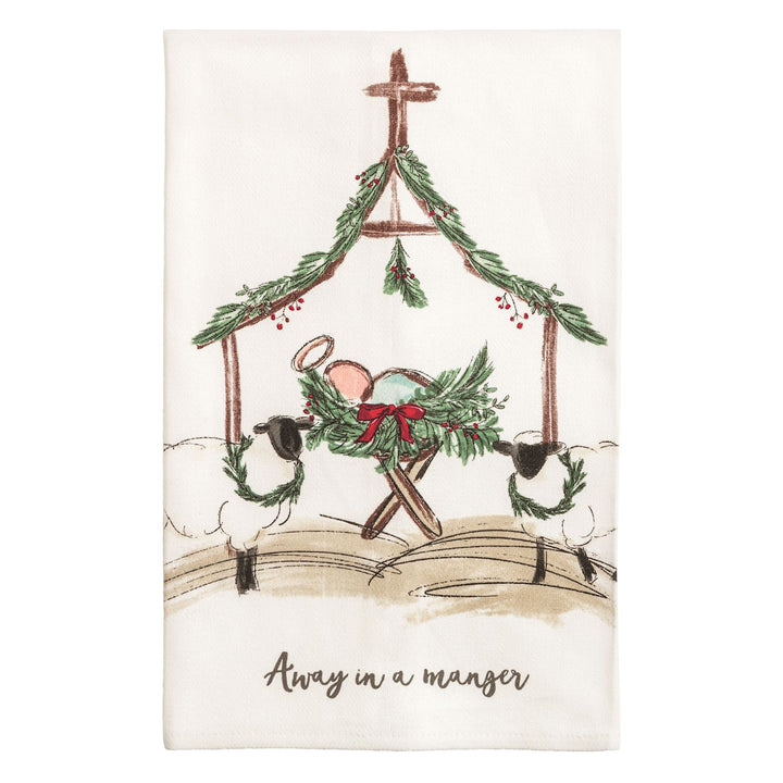 Two cream kitchen towels side by side: the left shows a watercolor nativity stable with a manger, two sheep wearing wreaths, evergreen garland, and the words &