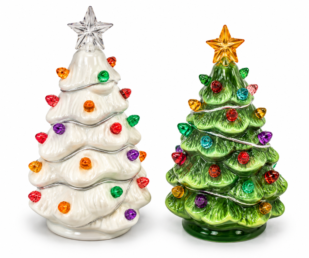 A glazed white ceramic Christmas tree figurine with tiered branch sculpting, multicolor faceted light bulb accents in red, orange, green, and purple, a silver garland detail, and a clear faceted star topper, photographed on a white background alongside a green ceramic tree.