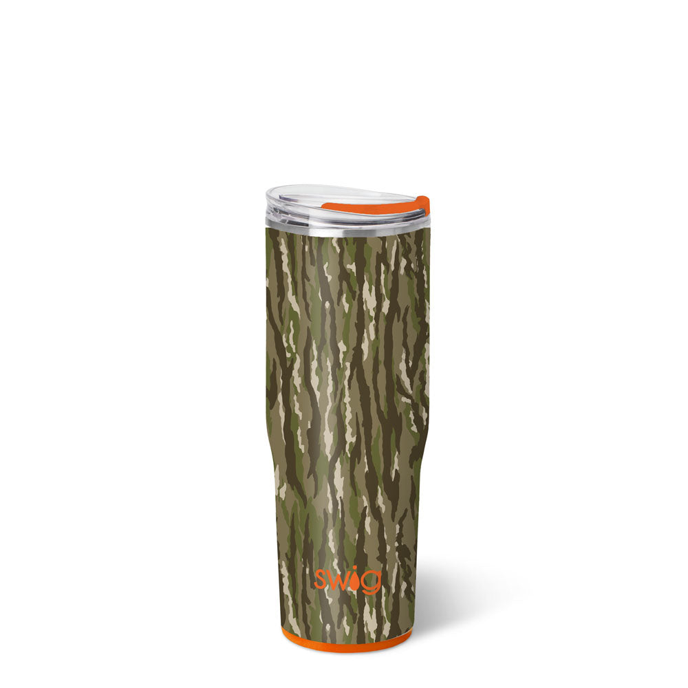 A tall 30oz Swig Life tumbler with a vertical-streak woodland camouflage print in olive green, dark brown, and tan, with an orange flip-top lid tab and orange base accent ring.