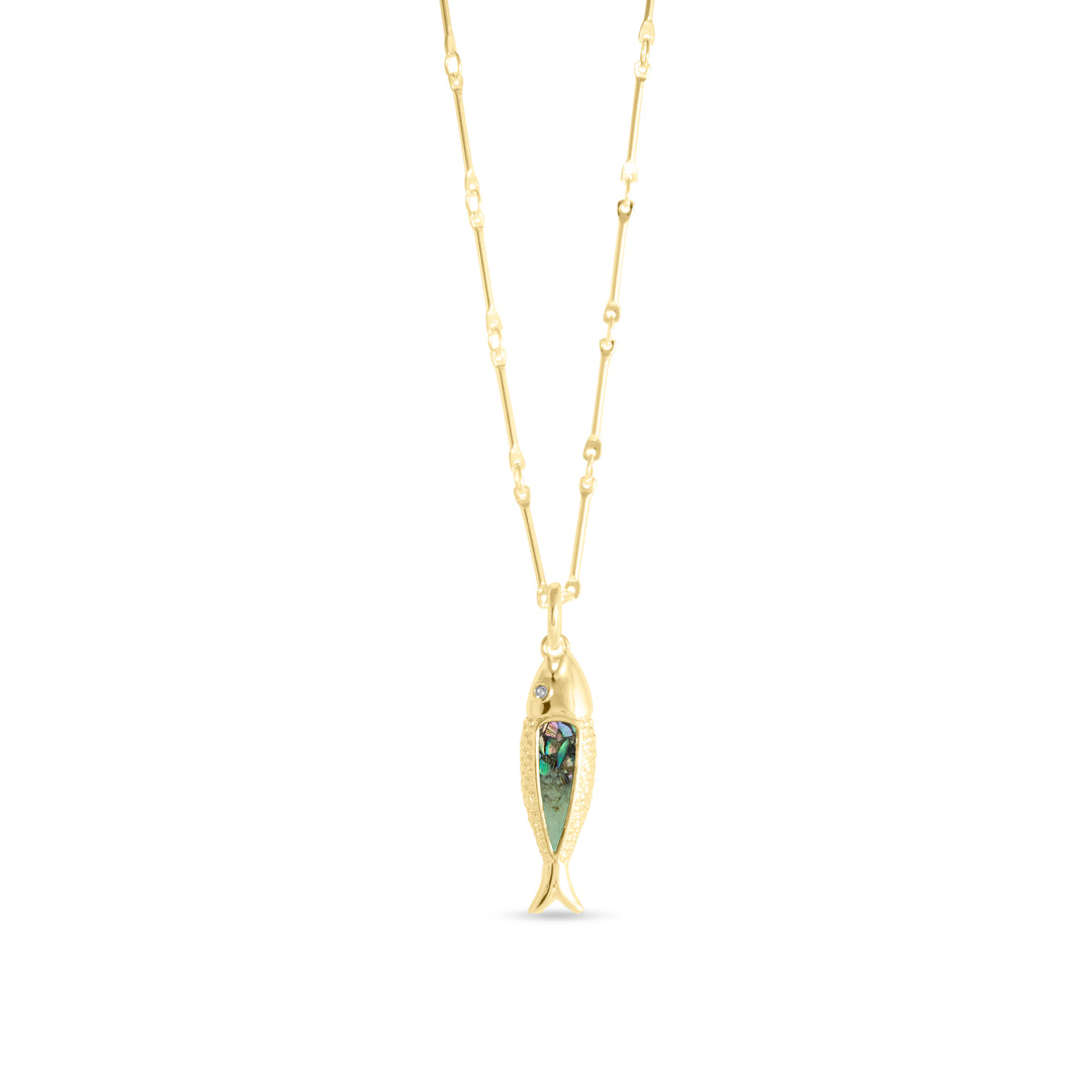 A gold-tone fish-shaped pendant necklace with an iridescent green and multicolor abalone gradient inlay and a small clear accent stone at the eye, suspended on an elongated oval and bar link chain against a white background.